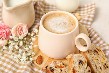 Delicious biscotti cookies, cup of coffee and gypsophila flowers on napkin