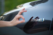 Purchaser hand showing thumb up sign at hybrid car new effective vehicle