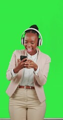 Canvas Print - Black woman, dancing with mobile phone and headphones on green screen, listen to music with fun and rhythm. Professional female with online streaming, tech and radio with freedom on studio background