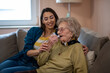 Young nurse caretaker helping grandma with her inhaler.