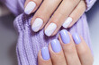 Female hands with a purple colour nails close-up. Nail design. Artistic manicure with a purple nail polish
