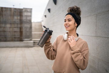 One young woman caucasian female hold supplement shaker outdoor in day