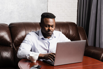 african american it developer with laptop is programming code in office. african business man workin