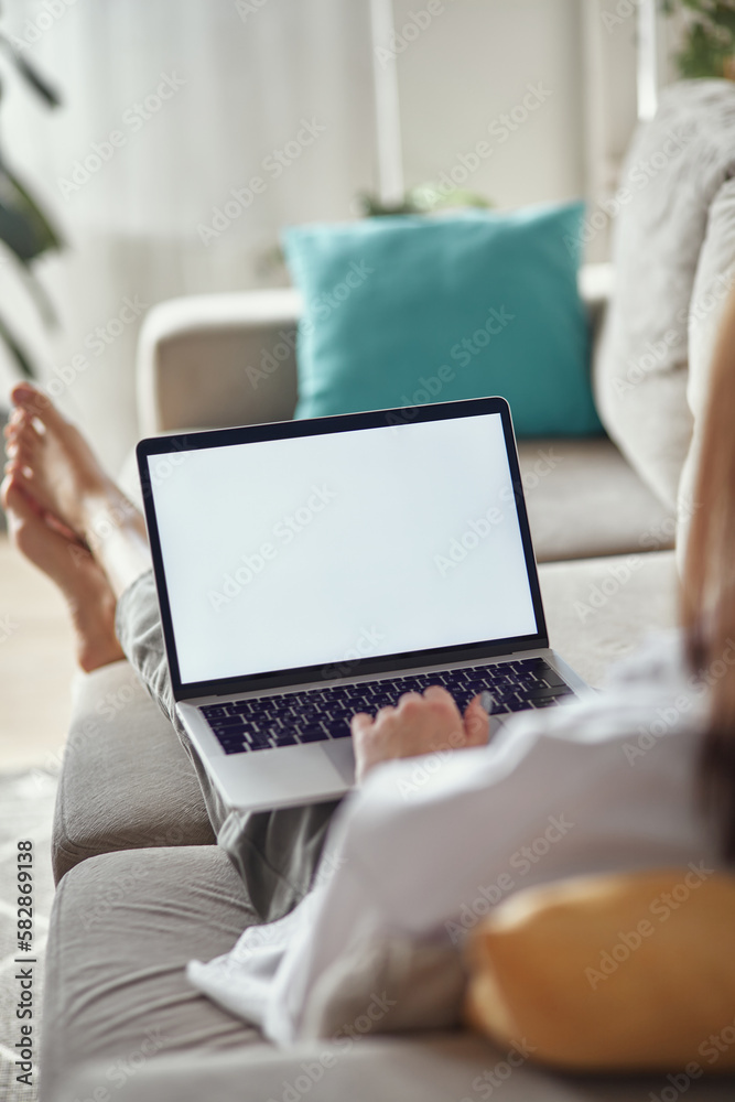 Mockup white screen laptop woman using computer lying on sofa at home ...