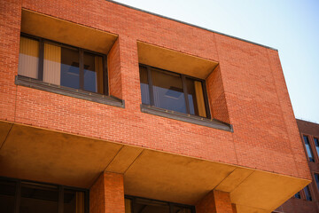 historic brick building structure with glass windows of urban apartment building old residential construction in boston downtown street with blue sky and business concept symbolizing monotonous work