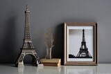 Fototapeta Boho - Two empty wooden picture frames and a figurine of the Eiffel Tower are displayed on a glass shelf in the living room against a gray backdrop. Generative AI