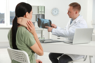 Doctor with neck MRI image consulting patient in clinic