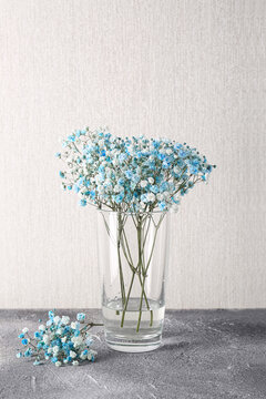 Wall Mural - Beautiful gypsophila flowers in vase on grey textured table against light wall