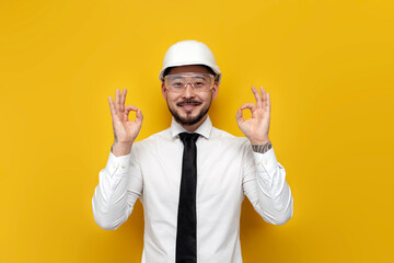 Wall Mural - asian foreman in shirt with tie showing ok with hands over yellow isolated background, korean civil engineer