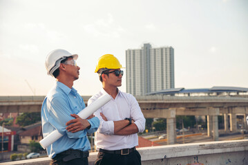 Two men engineer look at blueprint architecture building contractor design in modern city development. Males engineer holding project planing partner teamwork. Man meeting together construction site