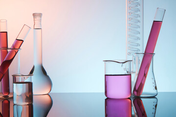 front view of laboratory equipment - test tube, beaker and boiling flask filled purple liquid, on pu