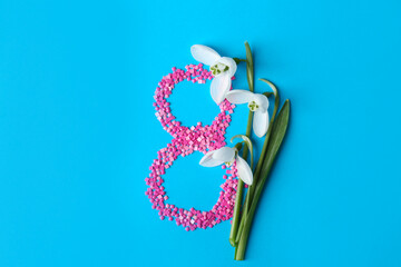 Wall Mural - Beautiful snowdrops and number 8 made of decorative mosaic stones on light blue background, flat lay