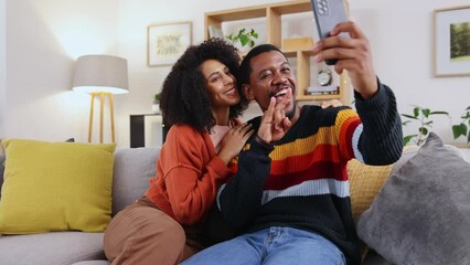 Poster - Selfie, home couch and couple with happiness and funny hand gesture for mobile photo. Social media, profile picture and living room sofa of young people sitting in the lounge feeling happy and silly