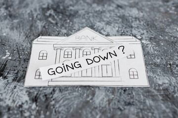 Wall Mural - insolvency and banks closing down concept, bank made of paper with Going Down ? caption above it