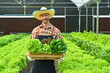 © Prathankarnpap - Portrait of smiling farmer holding wooden crate full of fresh organic vegetables from farm. Agriculture business concept
