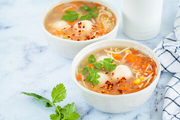 Canvas Print - Potato balls soup with noodles and vegetables in white bowl, white background. Vegan food concept.