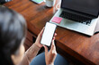 © Westend61 - Hands of businesswoman holding smart phone with blank screen at loft office