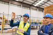 © Westend61 - Mature engineer wearing smart glasses gesturing by colleague in robotics factory