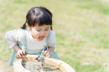 Canvas Print - 公園の水飲み場で水を飲む子供（育児・子育て）