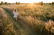 © Westend61 - Carefree girl running in field on summer evening