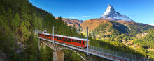 Zermatt, Switzerland. Gornergrat Red Tourist Train On The Bridge And Matterhorn Peak Panorama In Swiss Alps, Benner