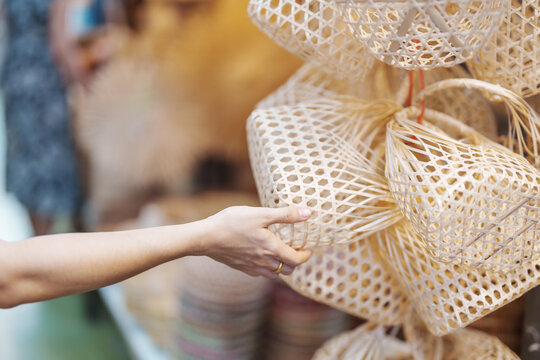 tourist hand holding craft bamboo basket in chatuchak weekend market, landmark and popular attractio