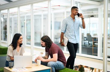 Aufkleber - Everyones productive in this office space. two businesspeople having a discussion in an office with their colleague walking in the background.