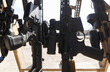 Modern American assault rifles equipped with optical scopes and magnifiers on weapon stand at outdoor shooting range