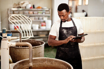 Poster - Its routine to check that all equipment operates perfectly. a man using a digital tablet while working in a bakery.