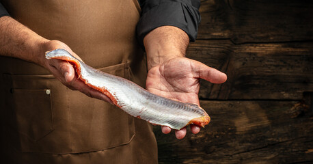 Wall Mural - salmon in hands. Chef's hand holding fresh fillet of salmon, banner, menu, recipe place for text