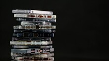 A Stack Of Audio Cassettes Spins On A Black Background And Mirror Surface. Golden Nineties.
