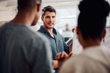 Poster - Visualising ideas goes a long way in business. a diverse group of businesspeople standing together and using a visual aid to brainstorm in the office.