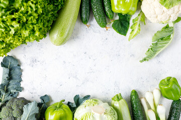 Wall Mural - Frame of green raw vegetables on white background. Top view of healthy organic food. Copy space