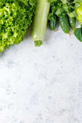 Wall Mural - Border of green raw vegetables on white background. Top view of healthy organic food. Copy space