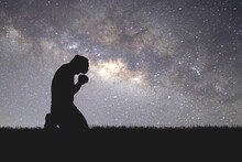 Man Silhouette Kneeling Praying To God Hopefully With The Beautiful Milky Way