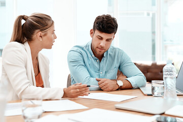 You understand. two young business colleagues going over some documents in the boardroom.