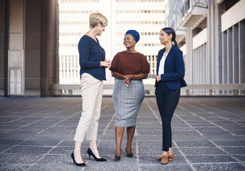 Poster - Business isnt just limited to the office. a group of businesswomen having a discussion against a city background.