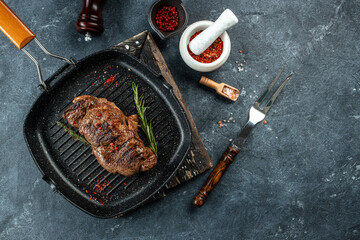 Wall Mural - Grilled beef steak with spices in a grill pan. place for text, top view