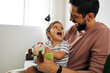 © kleberpicui - Father and baby son with teddy bear at home. Candid moment of father and son together.