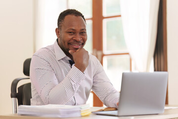 Wall Mural - Smiling American African makes financial report and studies annual figures, analyzes profits. Accountant checks status of financial