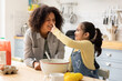 © ReeldealHD images - Daughter and Mom being playful whilst cooking in the kitchen