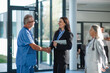 © Halfpoint - Young business woman shaking hand with elderly doctor.