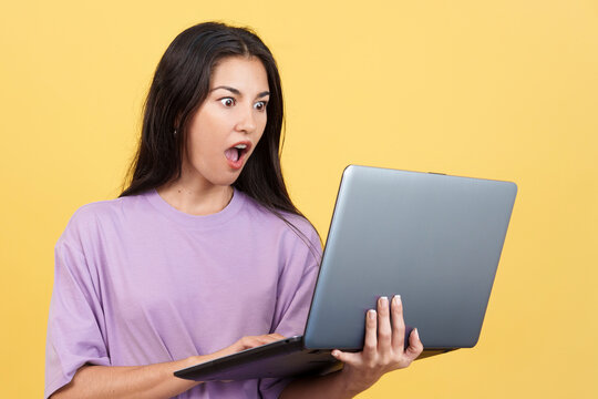 Caucasian woman with a surprised look using a laptop