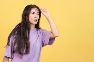 woman taking off her glasses to see far away