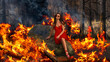© RooM The Agency - Woman in a red dress sitting on a rock in a burning forest