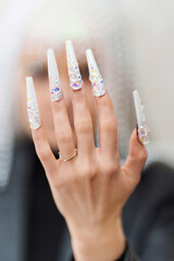 Female hand with white and long fake nails