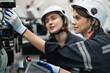 © chachamp - Two Engineer caucasian woman use remote control checking arm robot in the machine lap