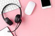 Helpdesk headset and computer accessories on pink background with copyspace. Call center