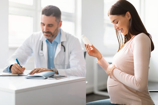 Wall Mural - Pregnancy and medication concept. Doctor prescribing pills for young pregnant woman during appointment in office