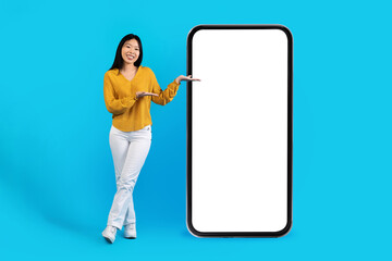 Attractive young asian woman showing nice app on blank sceen